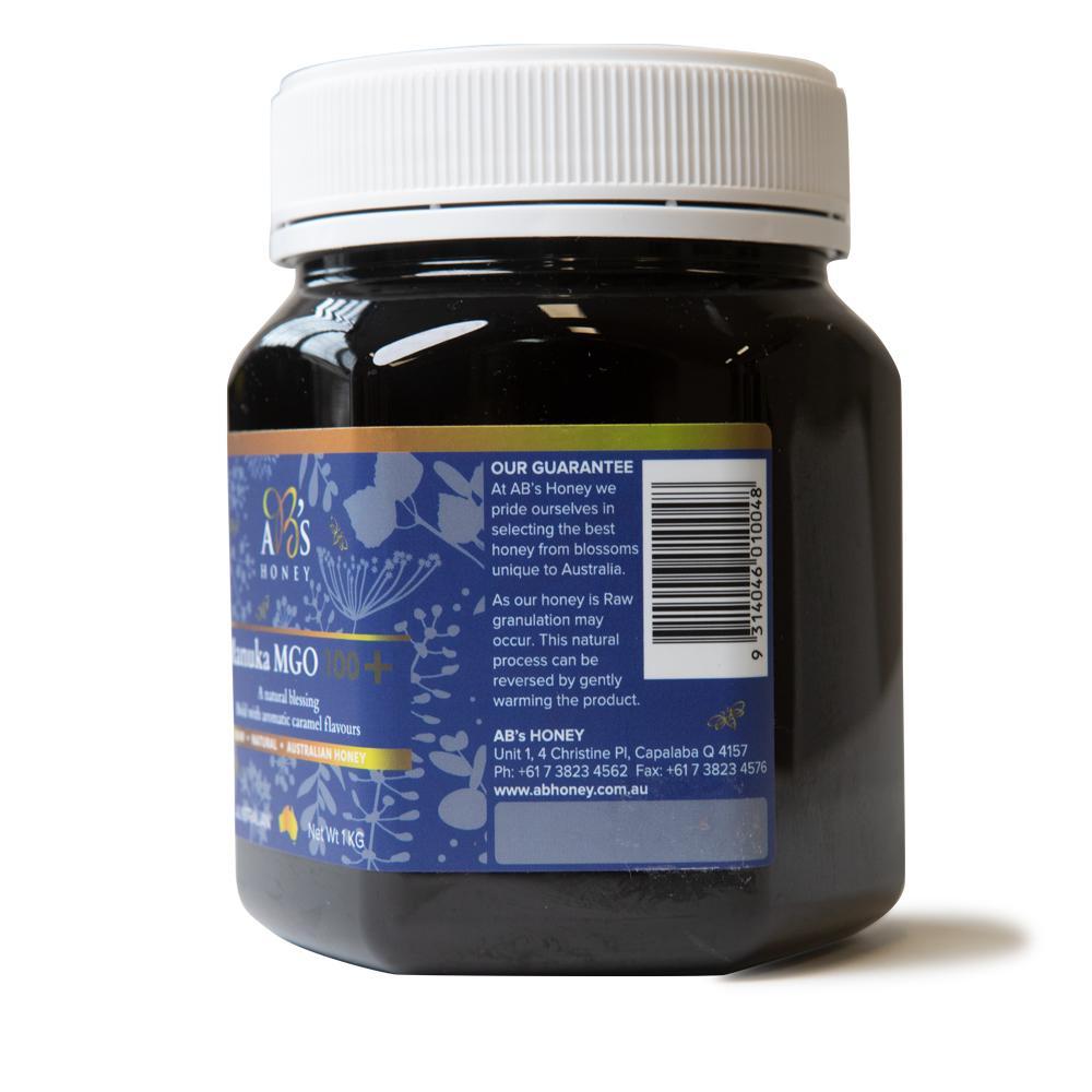 1Kg jar of AB's MGO 100+ Australian Manuka Honey, showcasing its rich dark color and label.