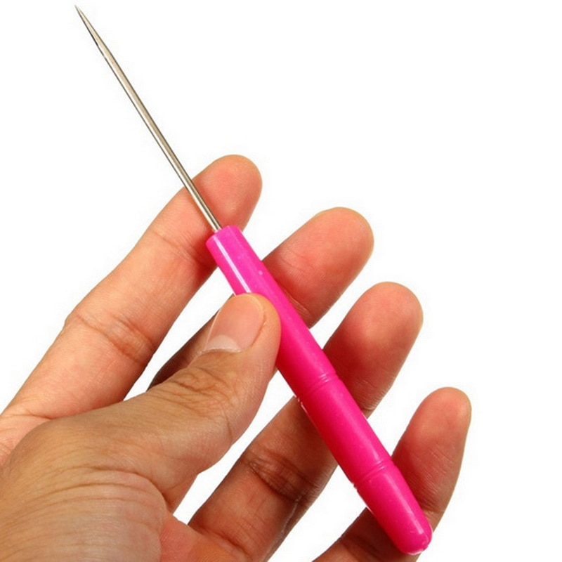 Hand holding pink needle tool.