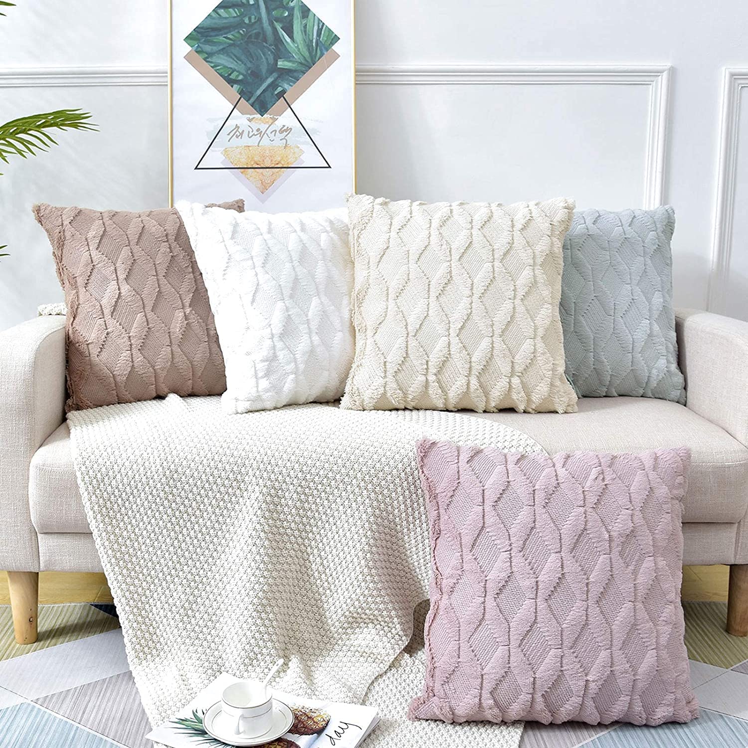 Two black decorative boho throw pillow covers with diamond design, made of soft faux fur and velvet, displayed on a cozy couch.