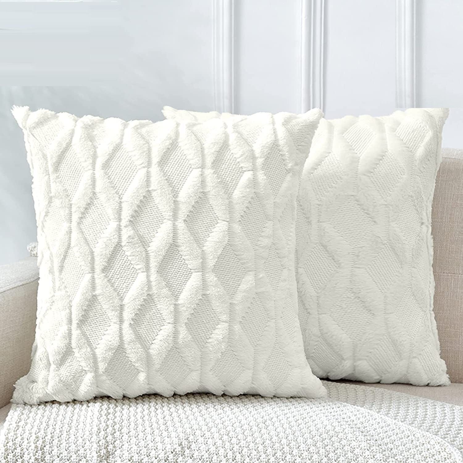 Two decorative boho throw pillow covers in white, featuring soft faux fur with a diamond design, perfect for home decor.