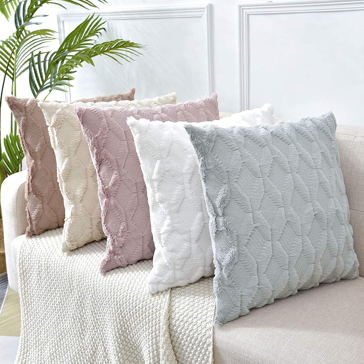 Two decorative boho throw pillow covers in white, featuring soft faux fur with a diamond design, perfect for home decor.