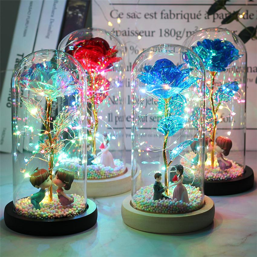 2020 LED Enchanted Galaxy Rose with 24K gold foil, illuminated by warm white LED lights, encased in a glass dome on a wooden base.