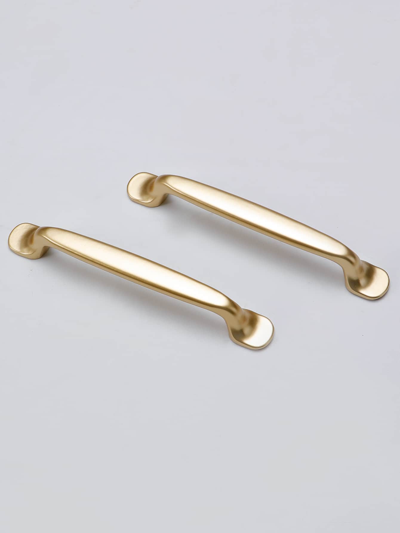 Two golden minimalist handles made of aluminum alloy, showcasing a sleek and modern design suitable for various furniture.