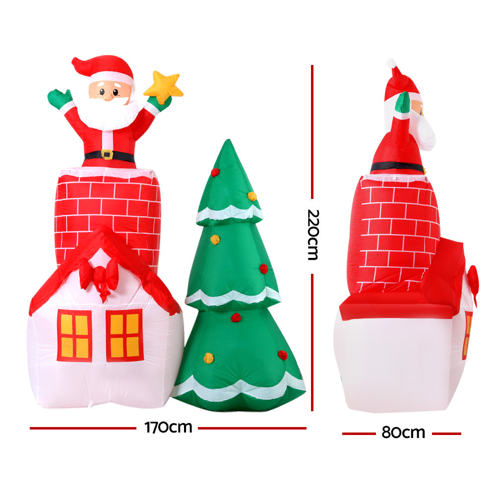 A vibrant 2.2M inflatable Santa in a chimney, surrounded by a colorful tree, perfect for Christmas decorations.