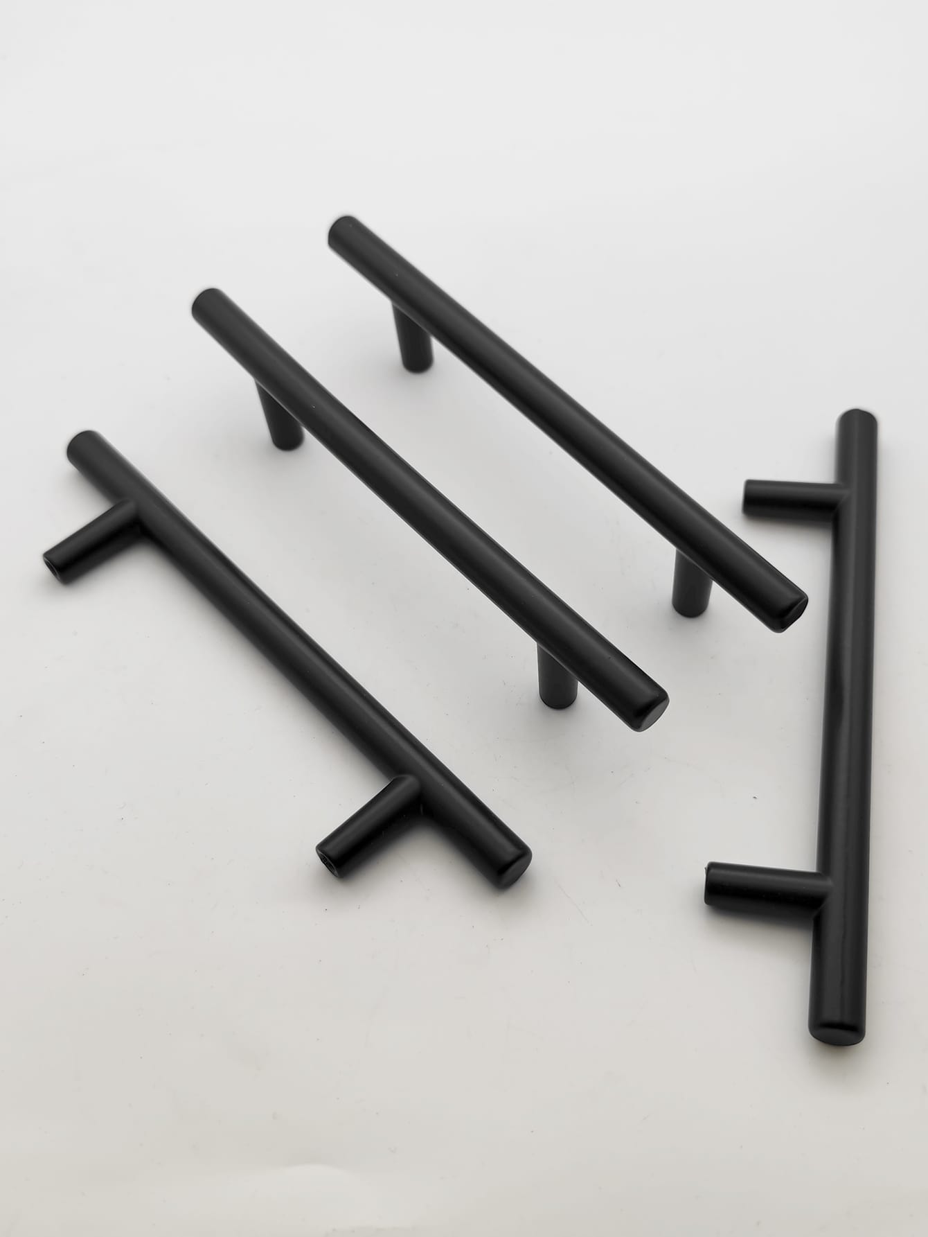 Set of four black cabinet handles made from aluminum alloy, showcasing a modern design suitable for various furniture styles.