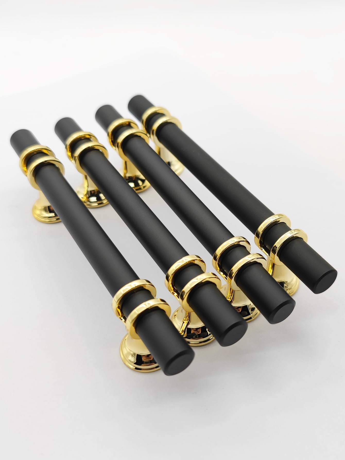 A set of four Lux design RST handles in black and gold, showcasing their elegant and modern style.