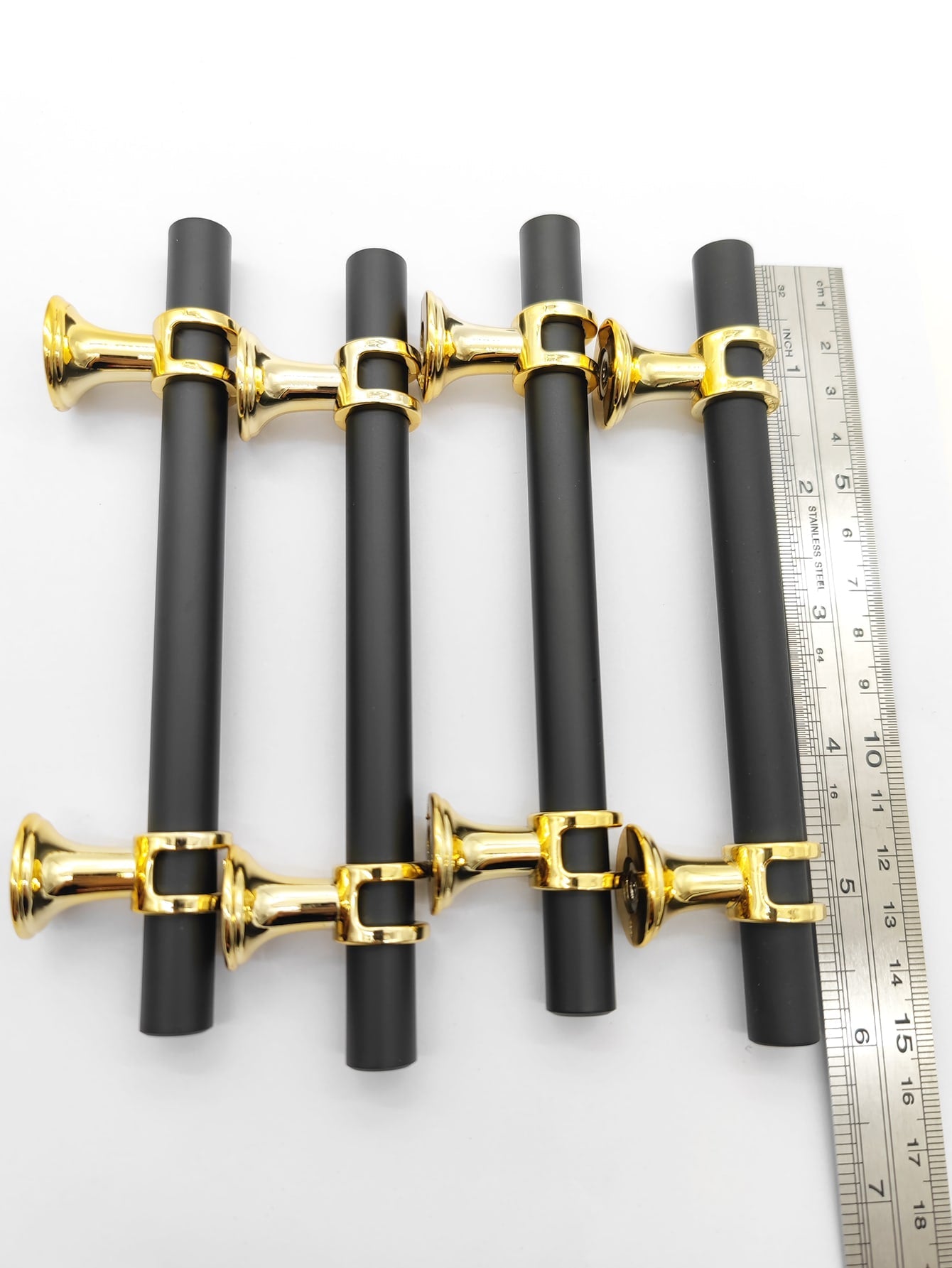 A set of four Lux design RST handles in black and gold, showcasing their elegant and modern style.