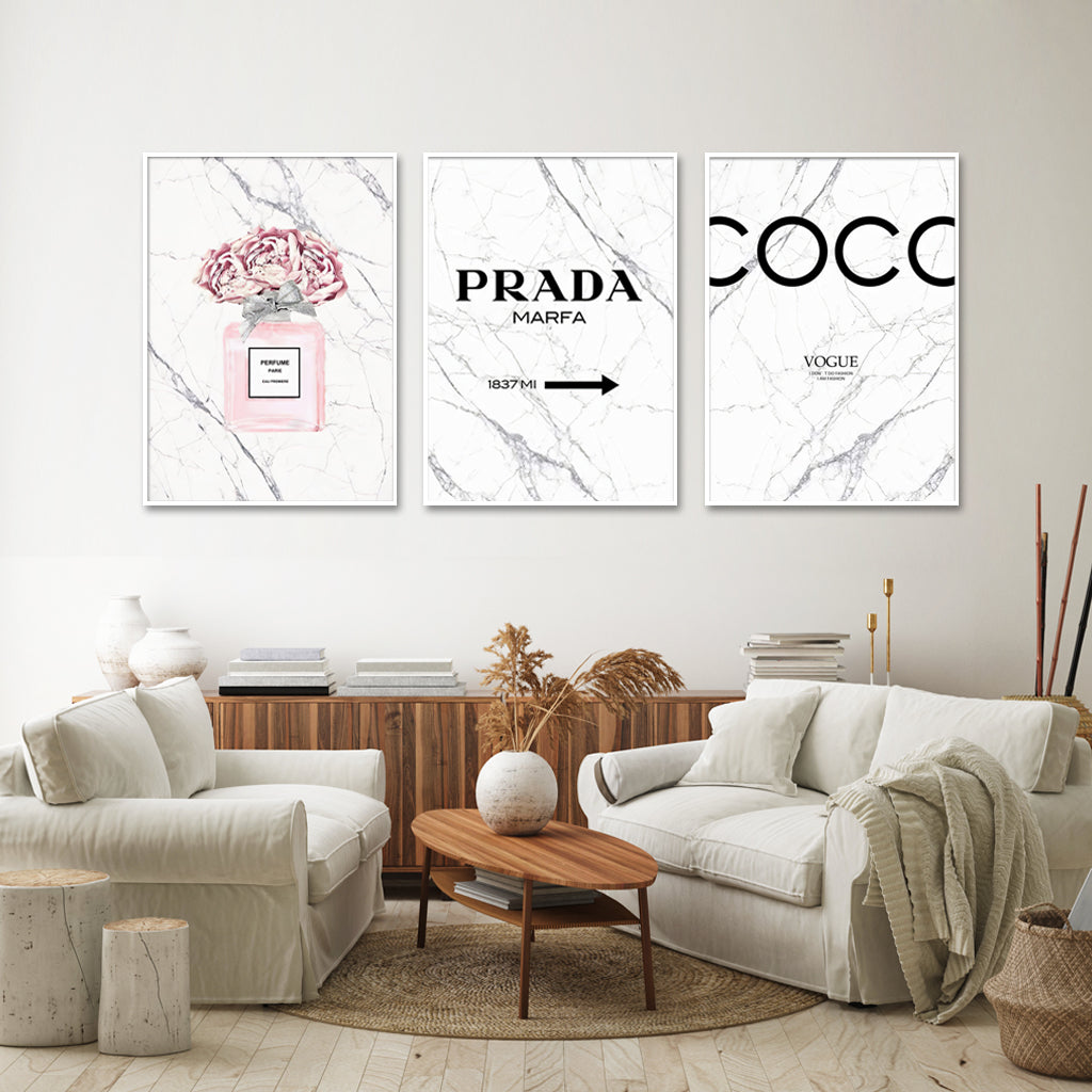 Three elegant canvas prints featuring fashion perfume designs, framed in white, showcasing vibrant colors and a modern floating effect.