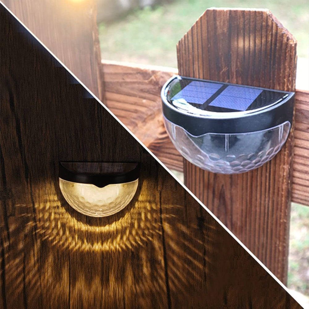 Four solar powered LED wall lights made of stainless steel, designed for outdoor use, illuminating pathways and gardens.