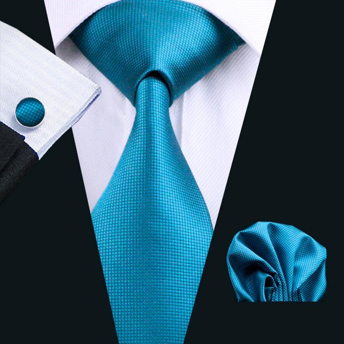 A stylish set of 50 solid color silk men's ties with matching handkerchief and cufflinks, showcasing various colors and elegant design.