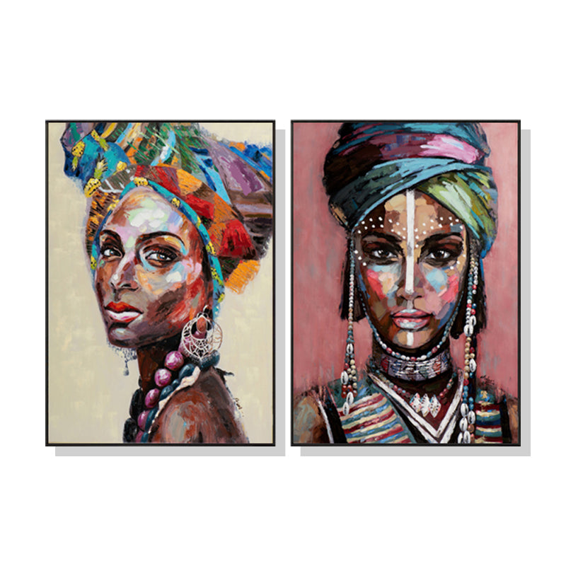 A beautifully framed 50cmx70cm canvas wall art depicting African women, showcasing vibrant colors and a modern black frame.