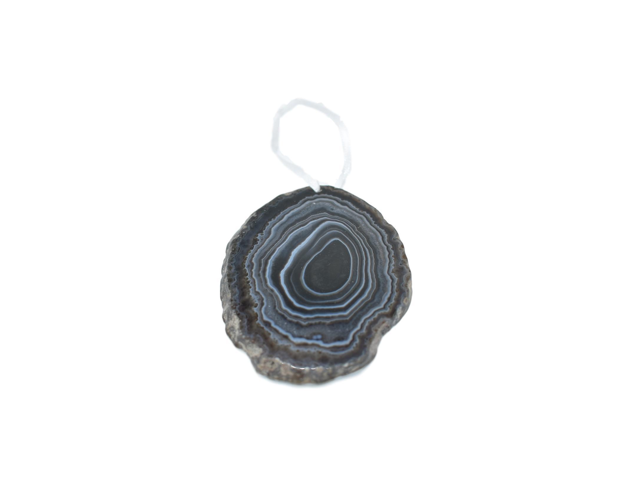 A beautiful agate ornament with a polished natural trim, hanging from a white silk ribbon, showcasing its unique colors and patterns.