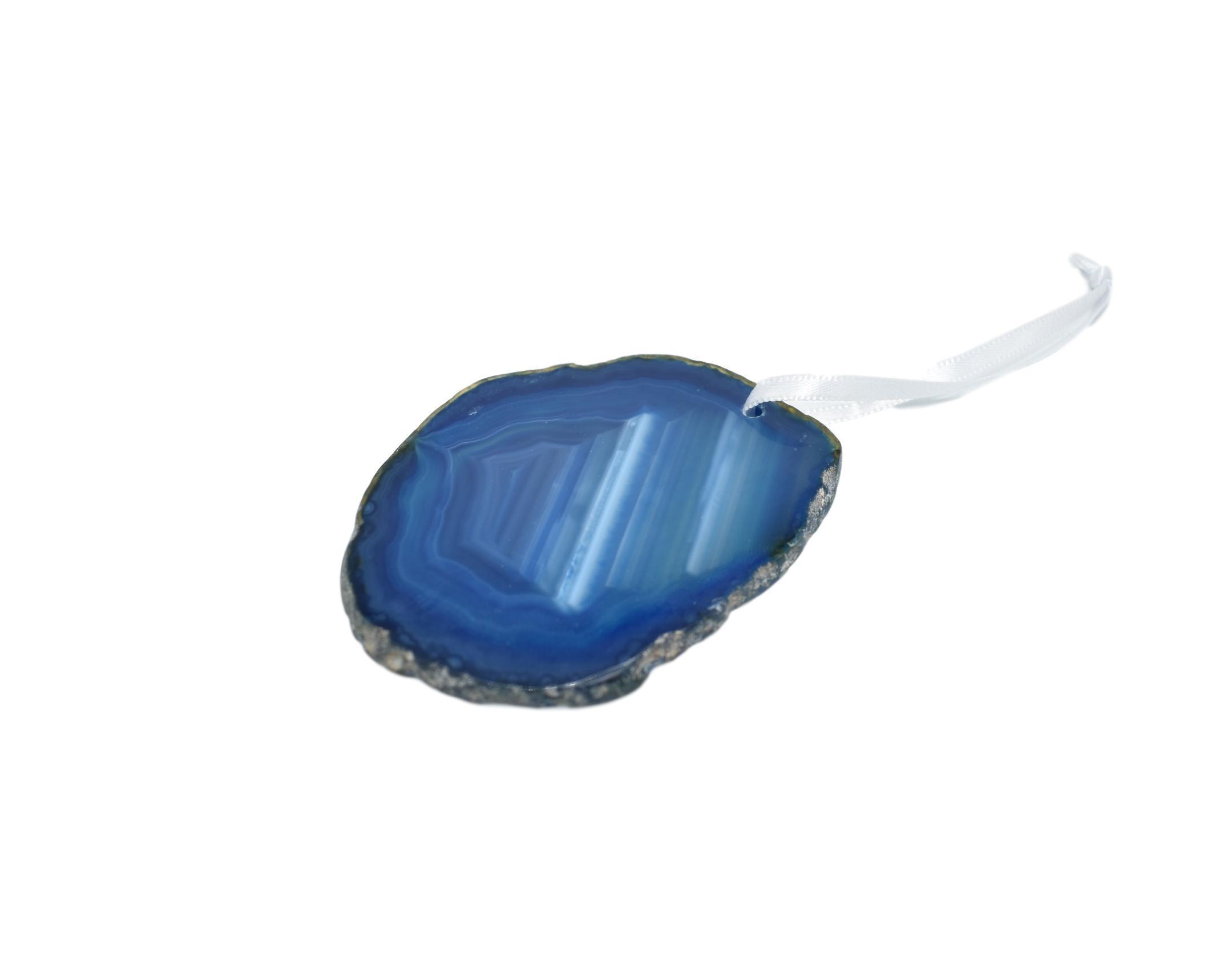 A beautiful agate ornament with a polished natural trim, hanging from a white silk ribbon, showcasing its unique colors and patterns.