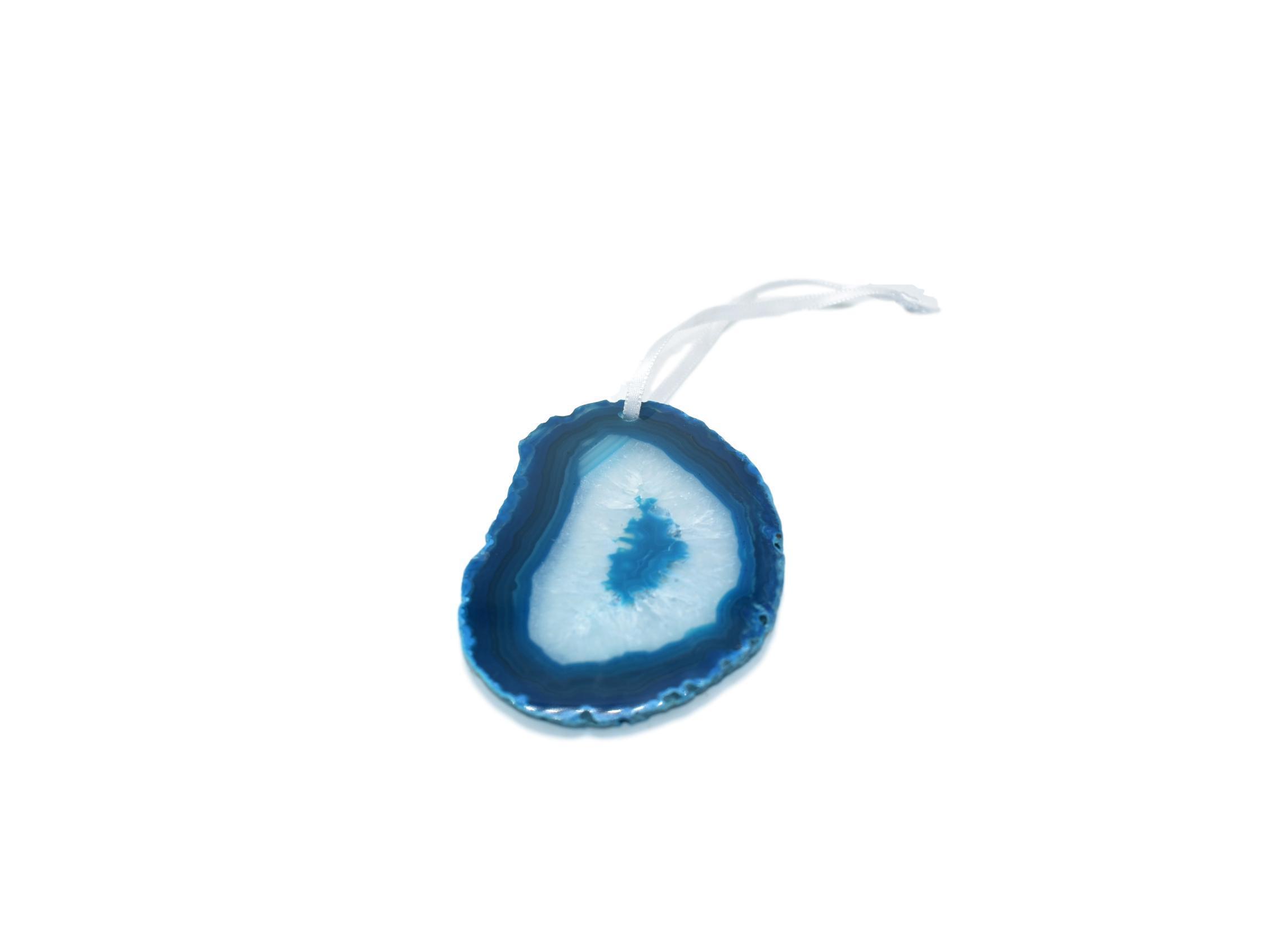 A beautiful agate ornament with a polished natural trim, hanging from a white silk ribbon, showcasing its unique colors and patterns.