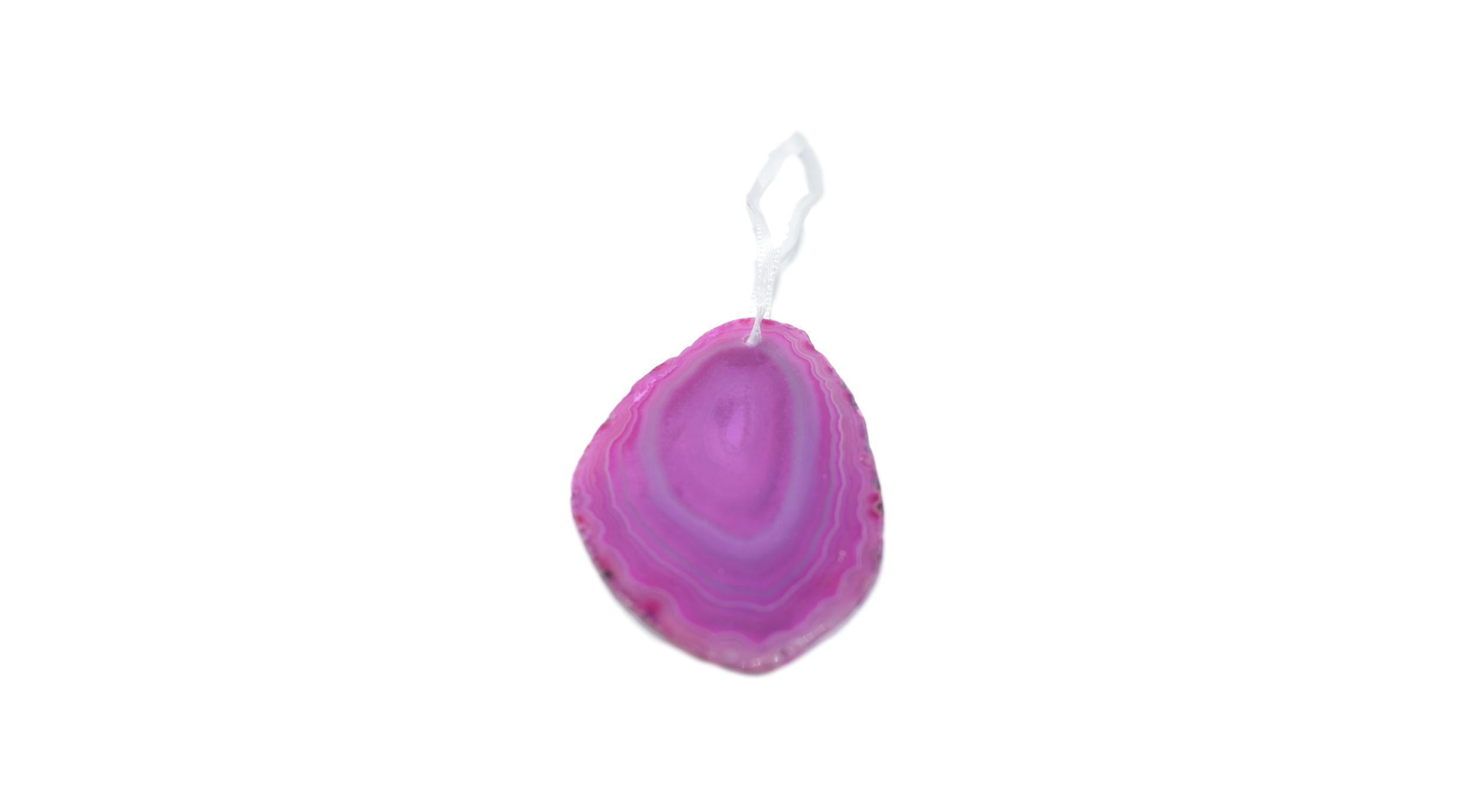 A beautiful agate ornament with a polished natural trim, hanging from a white silk ribbon, showcasing its unique colors and patterns.