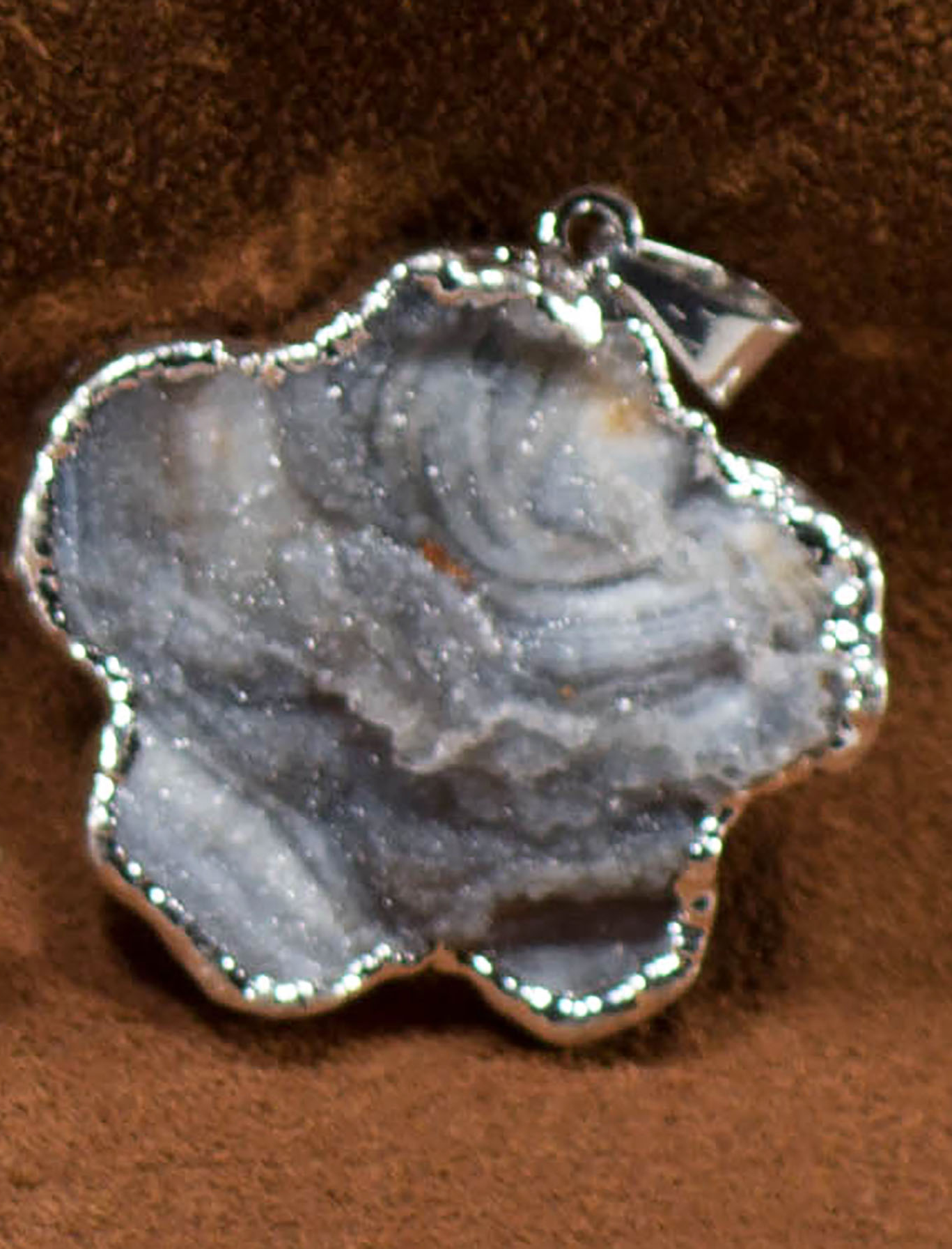 A collection of elegant agate sculpture pendants in various designs, including leaf, heart, and dolphin, trimmed in silver and gold.