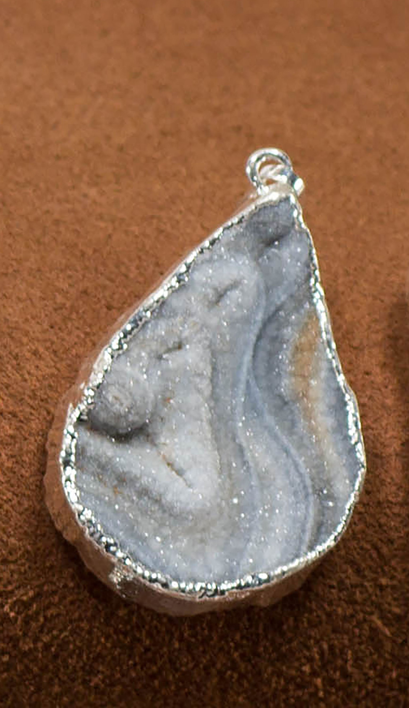 A collection of elegant agate sculpture pendants in various designs, including leaf, heart, and dolphin, trimmed in silver and gold.