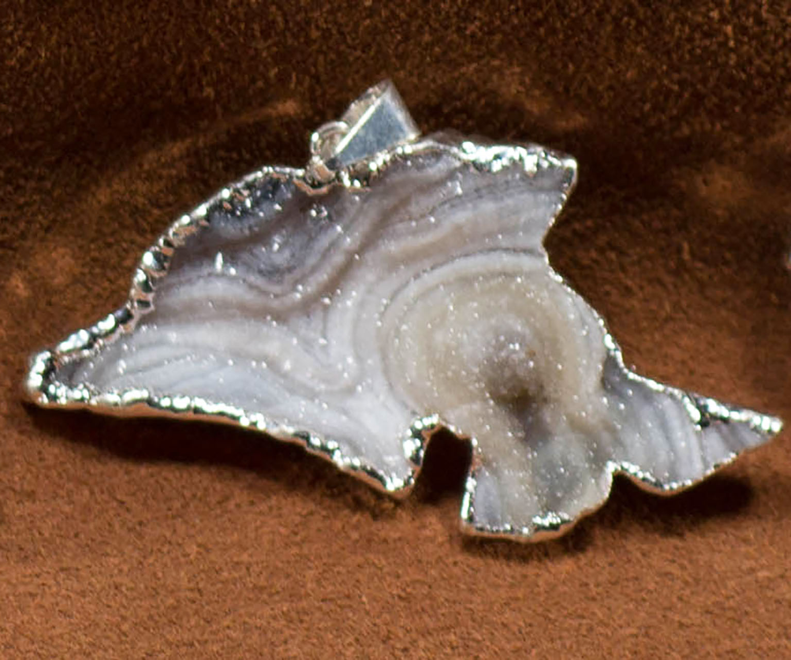 A collection of elegant agate sculpture pendants in various designs, including leaf, heart, and dolphin, trimmed in silver and gold.