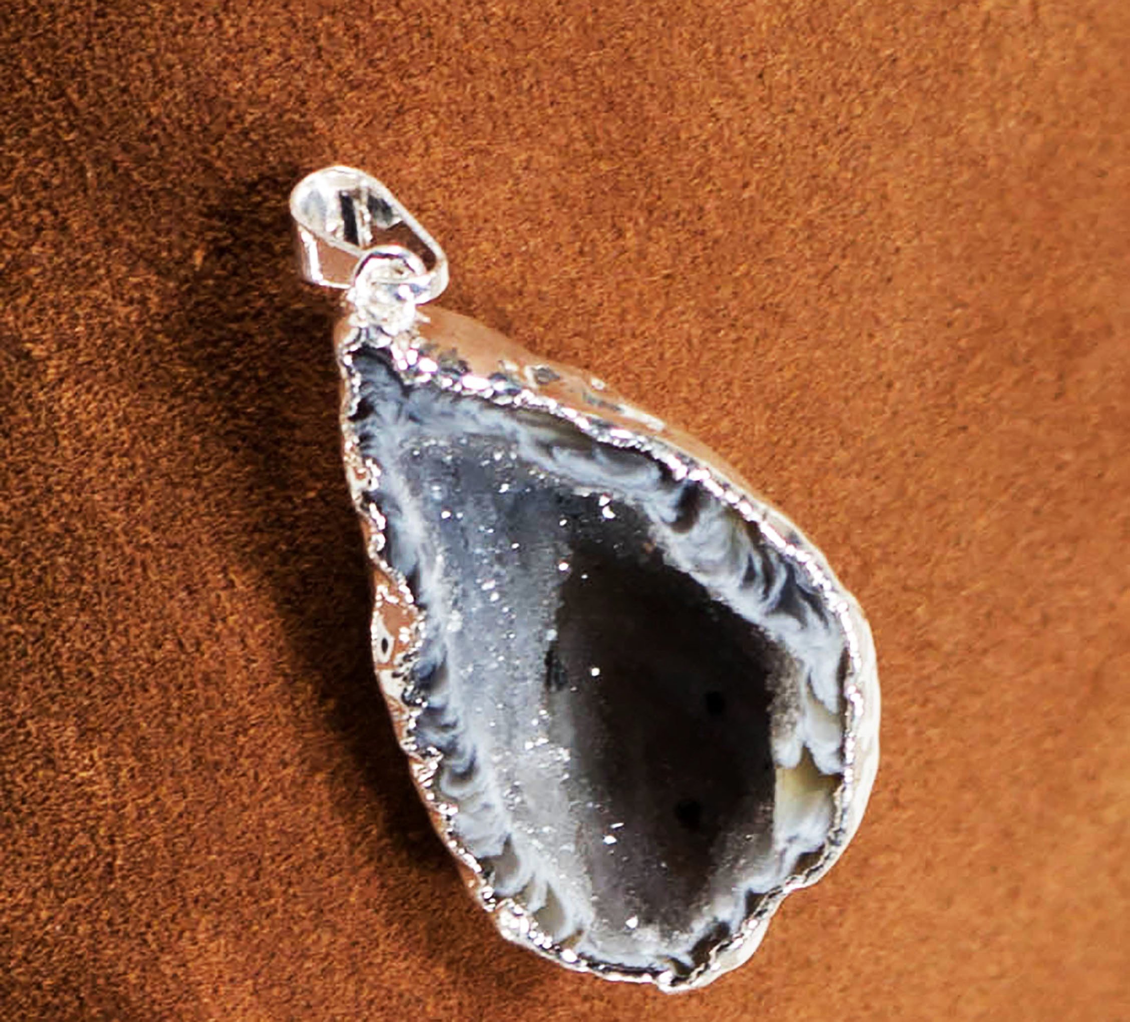 A collection of elegant agate sculpture pendants in various designs, including leaf, heart, and dolphin, trimmed in silver and gold.