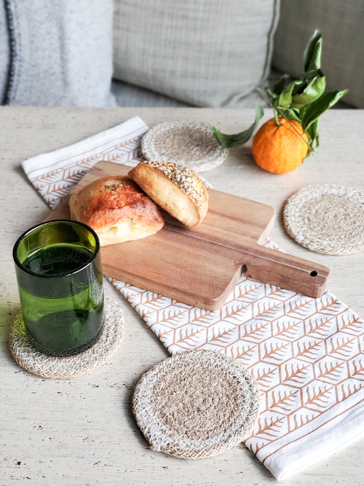 Set of 4 handmade jute drink coasters in natural and white colors, perfect for protecting surfaces.