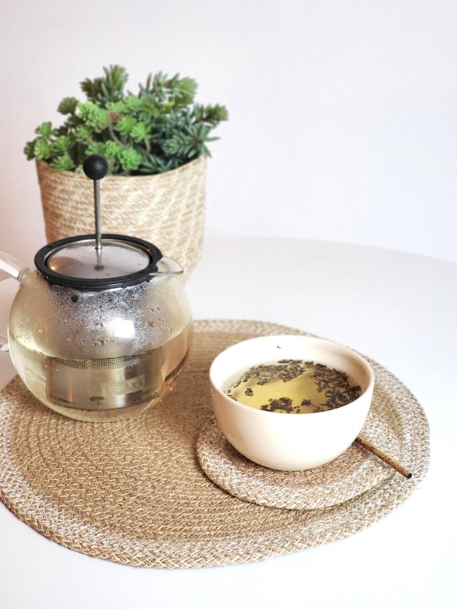 Set of 4 round jute placemats in natural and white colors, showcasing their textured design and handcrafted quality.