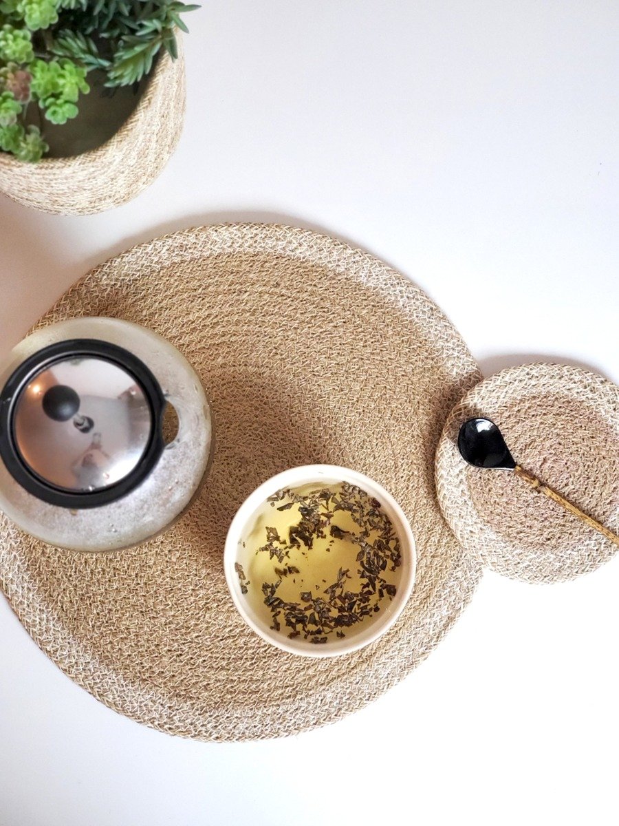 Set of 4 round jute placemats in natural and white colors, showcasing their textured design and handcrafted quality.