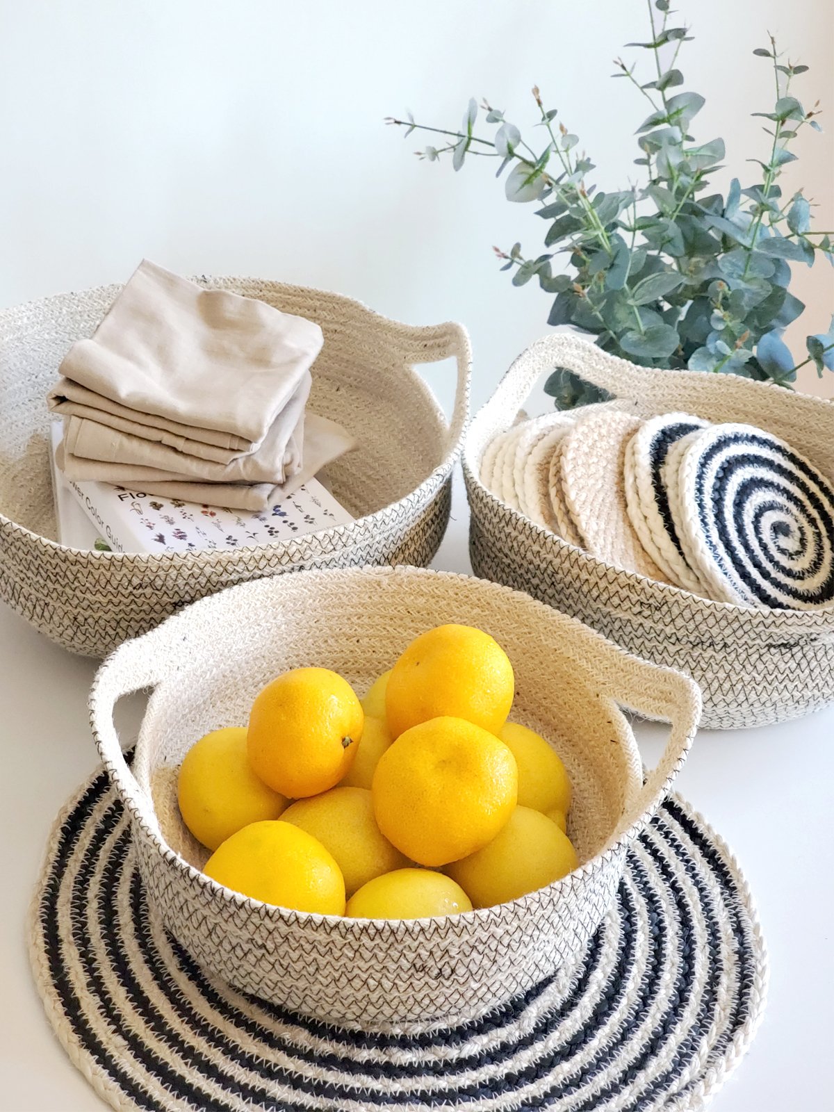 Amari Fruit Bowl in black with off-white jute, handwoven and featuring elegant stitching, perfect for fruit or decorative use.