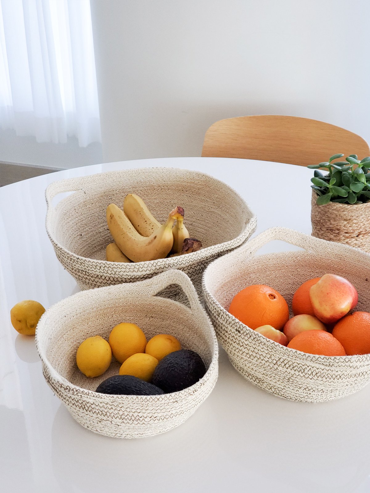 Amari Fruit Bowl in brown, handwoven jute with black stitching, showcasing its elegant design and craftsmanship.