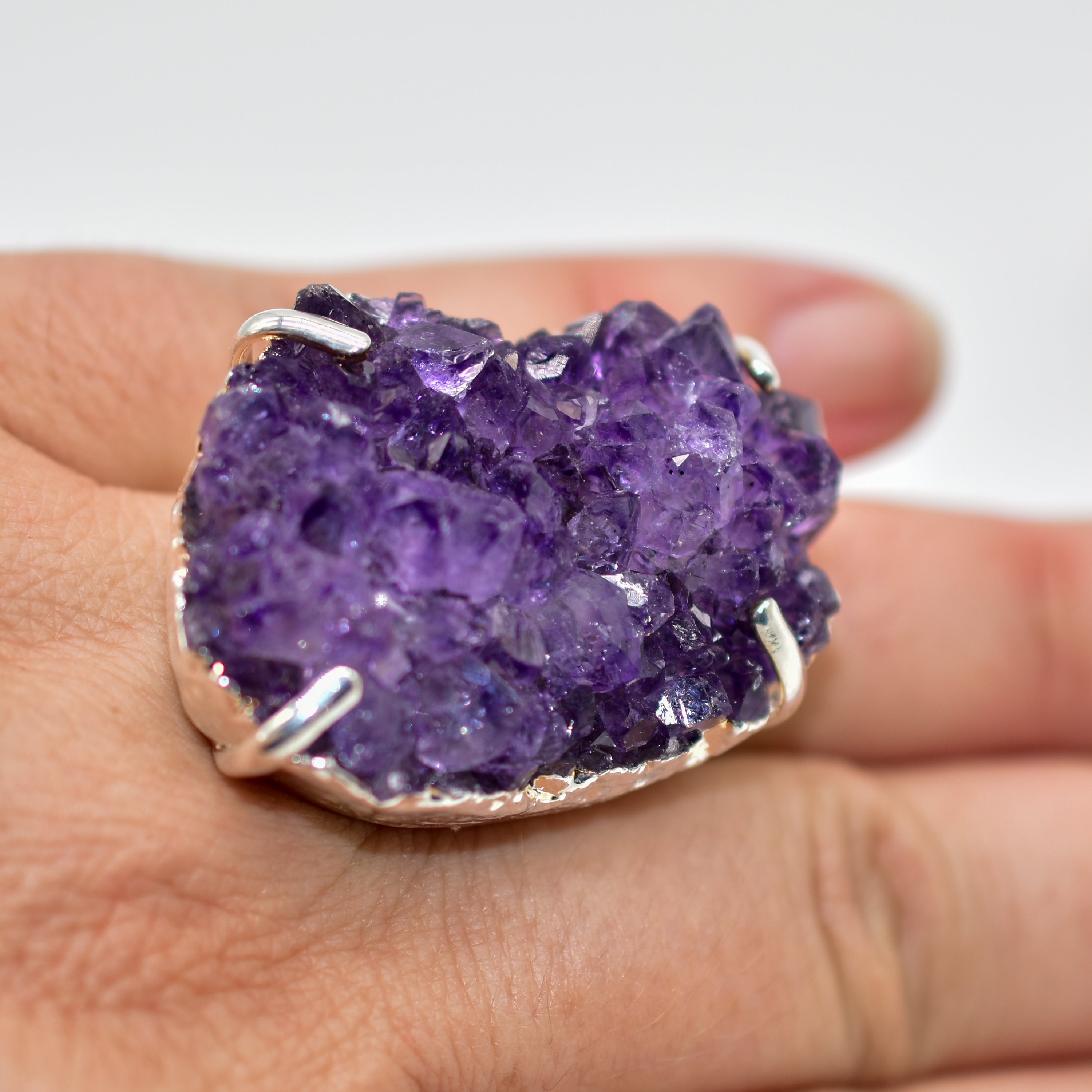 A stunning Amethyst Druzy Ring featuring a natural druzy stone wrapped in silver electroplating, showcasing its unique shape and vibrant color.