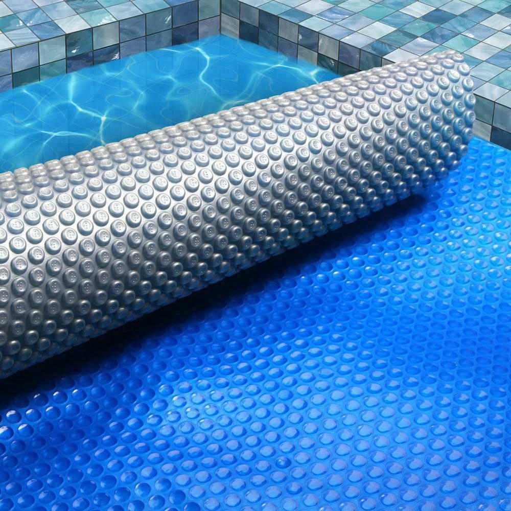 Aquabuddy 11M X 4.8M Solar Swimming Pool Cover in blue with a silver underside, showcasing its bubble design for heat retention.