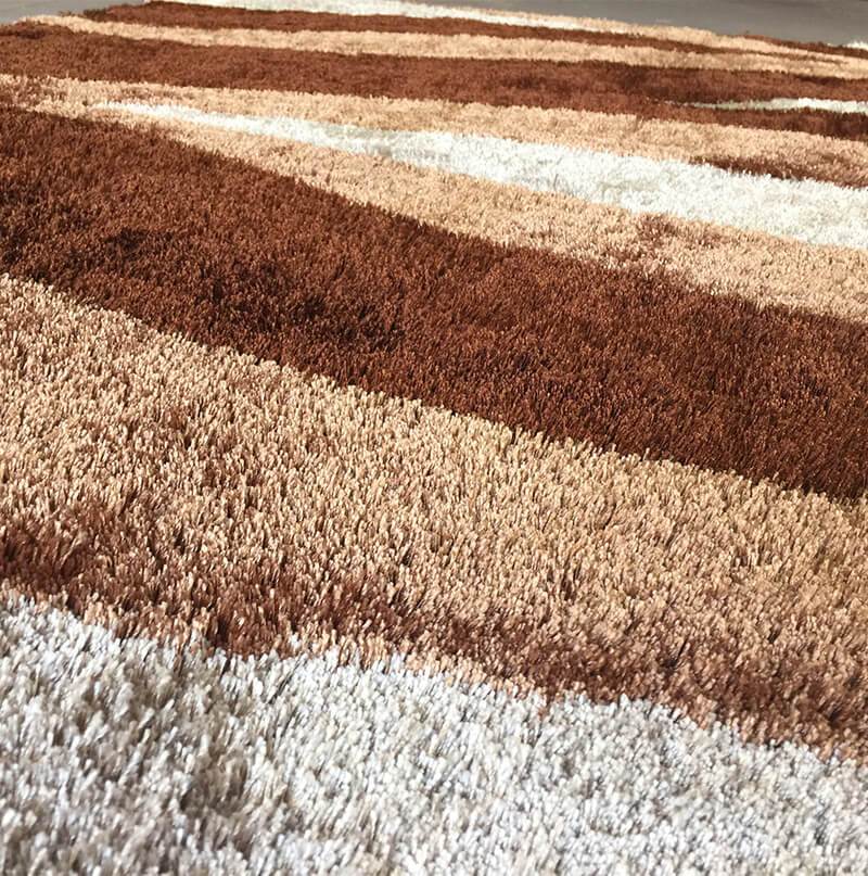 Aria Beige & Brown Soft Pile Shaggy Area Rug displayed in a cozy living room setting, showcasing its plush texture and modern design.