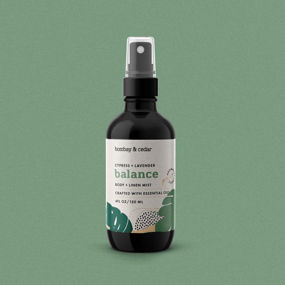 Aromatherapy Body + Linen Mist - Balance in a sleek spray bottle, surrounded by natural ingredients like lavender and eucalyptus leaves.