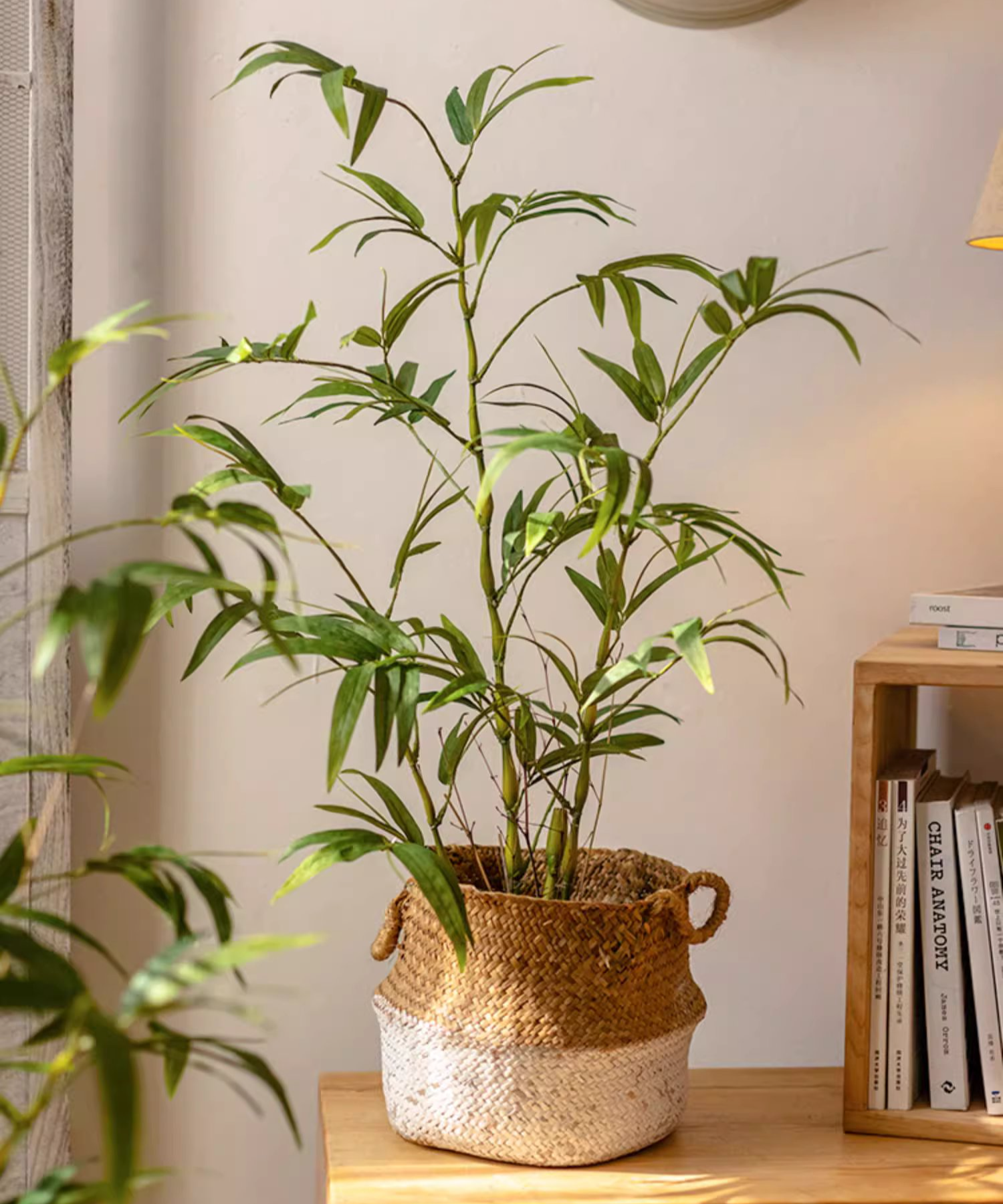 Lifelike artificial bamboo leaves in a black pot, showcasing vibrant green foliage.