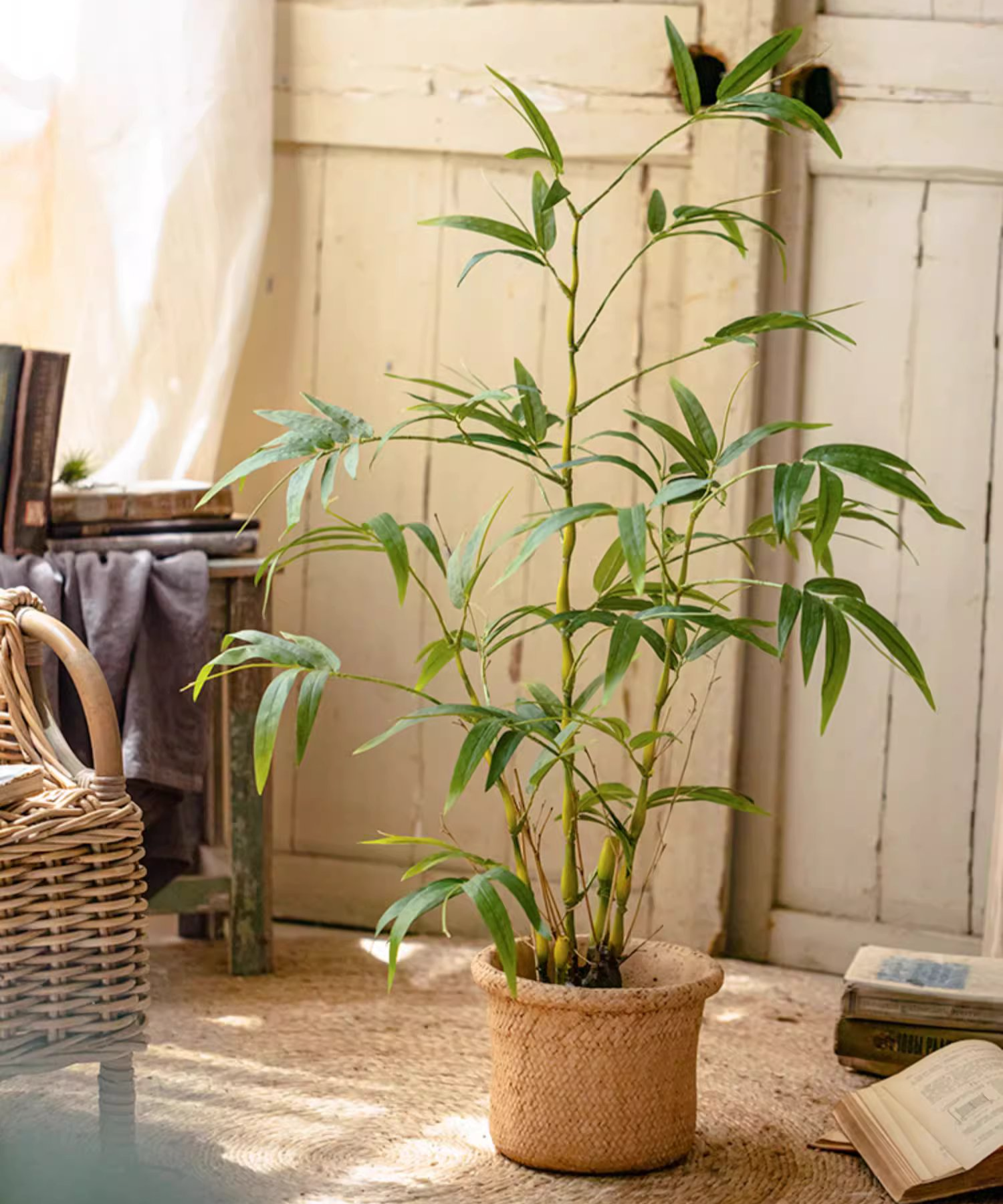 Lifelike artificial bamboo leaves in a black pot, showcasing vibrant green foliage.