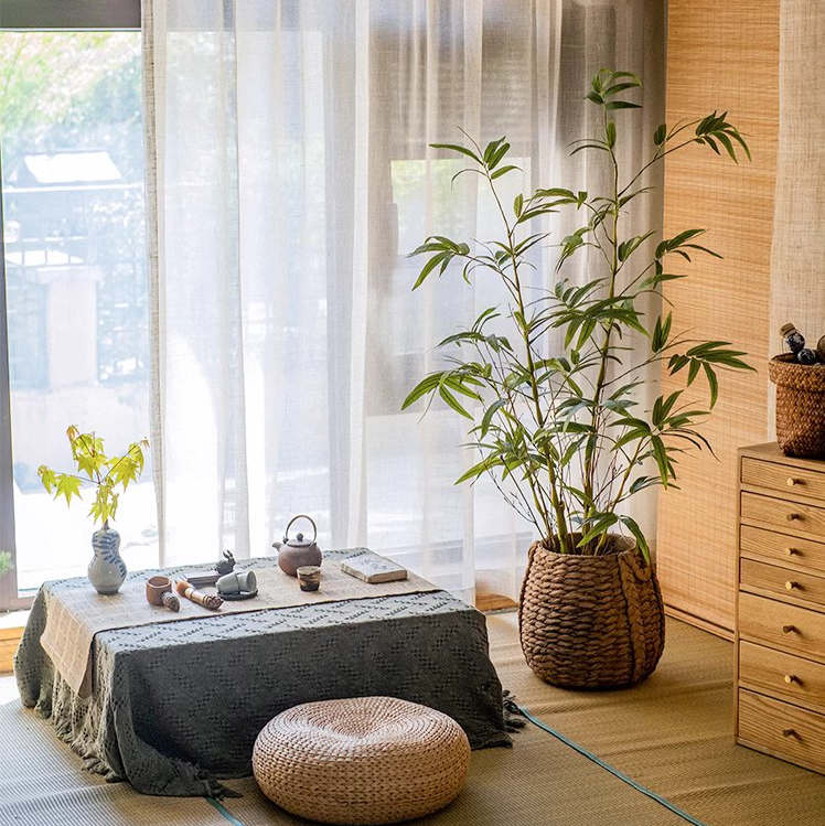 Lifelike artificial bamboo leaves in a black pot, showcasing vibrant green foliage.