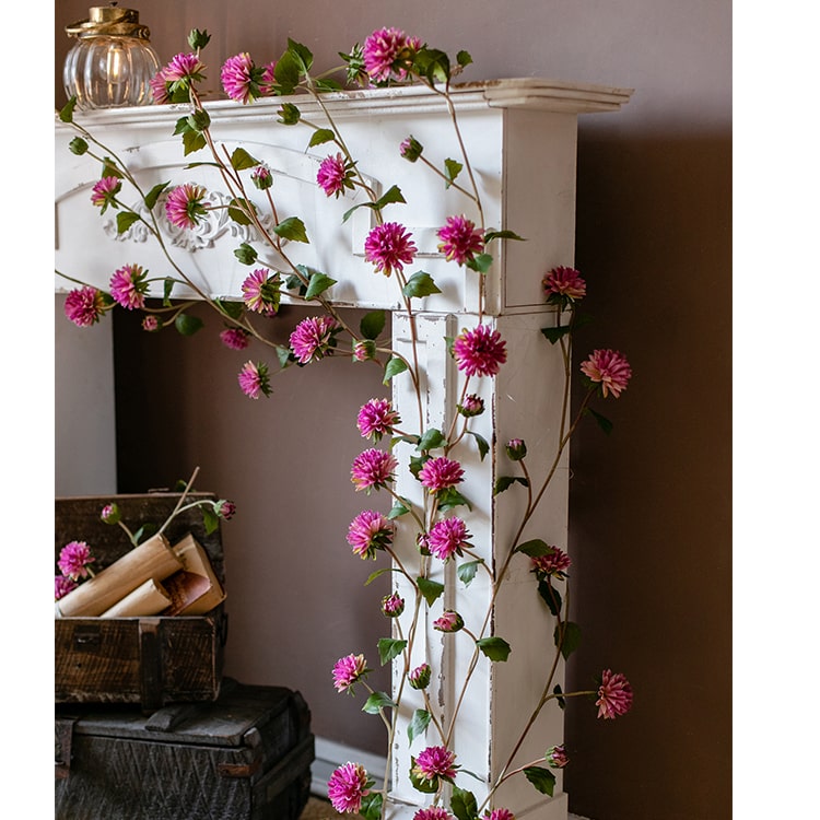 A long artificial chrysanthemum flower vine in rose color with green leaves, showcasing realistic silk flowers.