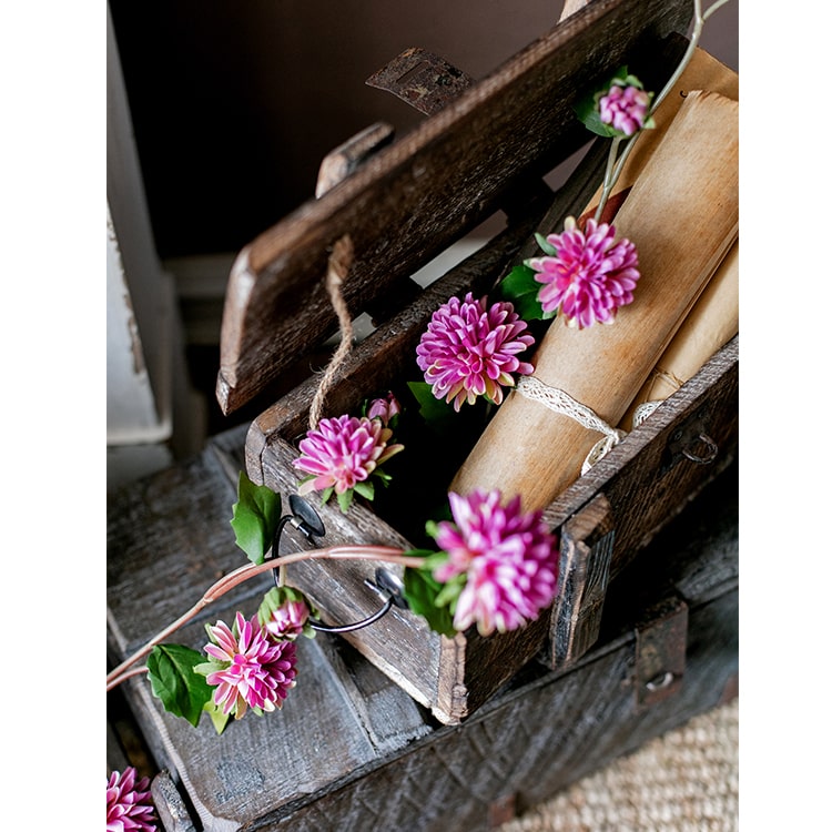 A long artificial chrysanthemum flower vine in rose color with green leaves, showcasing realistic silk flowers.