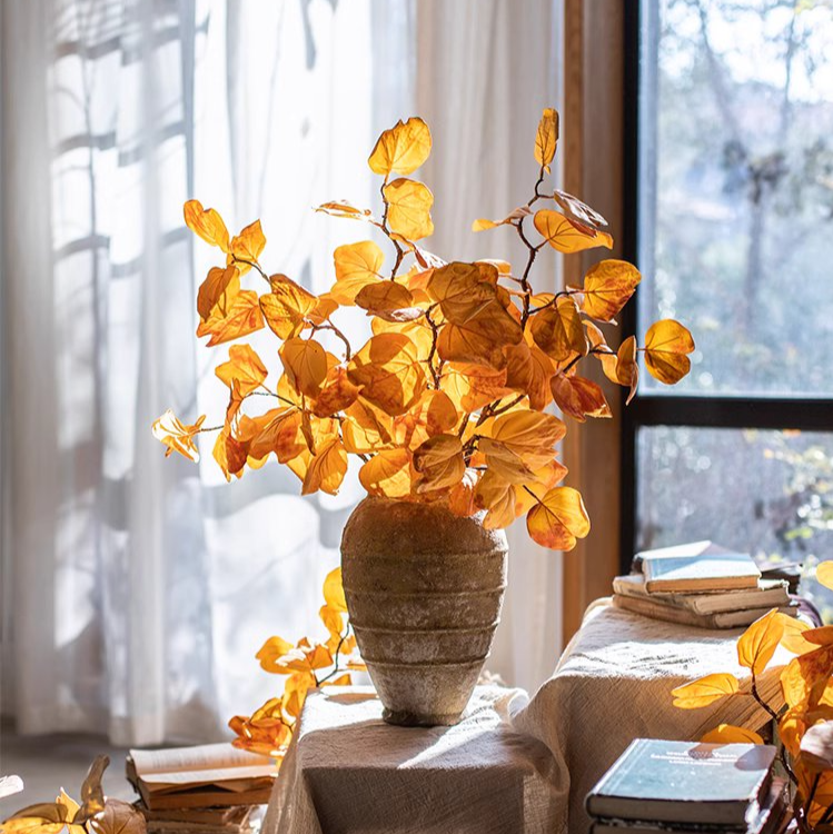 A 33-inch tall artificial dry apple leaf stem in natural yellow color, showcasing realistic leaves made of plastic and silk cloth.