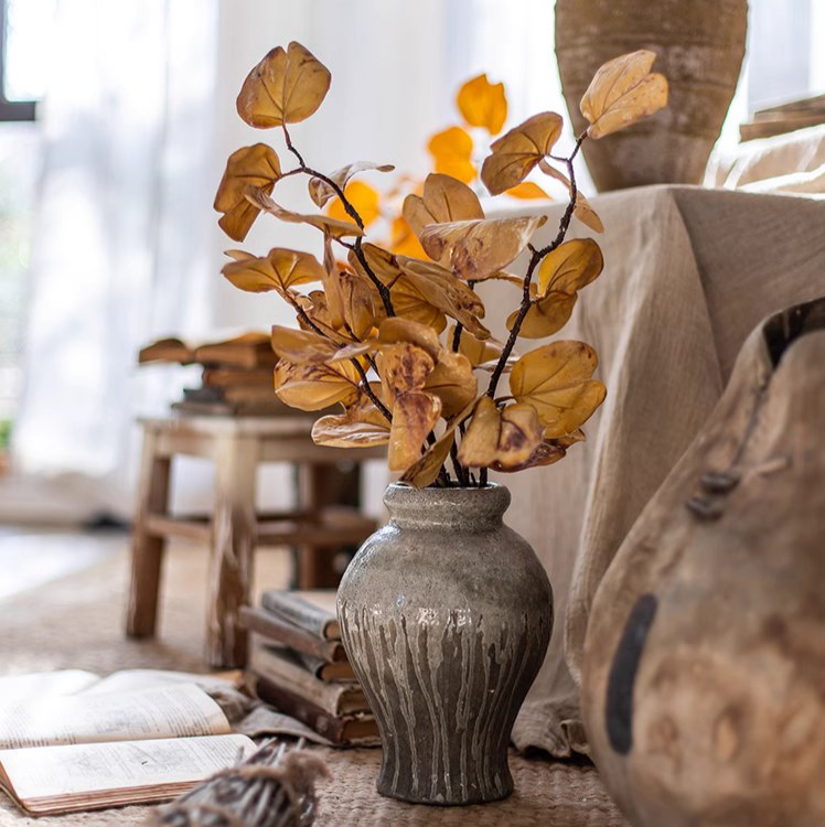 A 33-inch tall artificial dry apple leaf stem in natural yellow color, showcasing realistic leaves made of plastic and silk cloth.