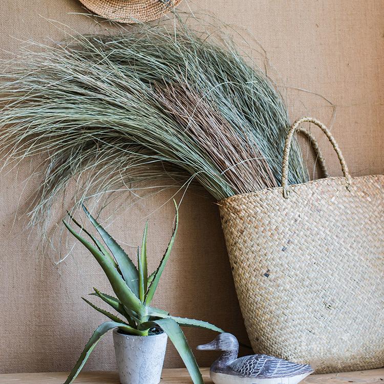 A bundle of artificial faux dried grass in green and khaki colors, showcasing its realistic texture and natural appearance.