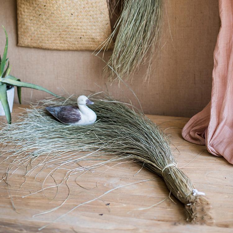 A bundle of artificial faux dried grass in green and khaki colors, showcasing its realistic texture and natural appearance.