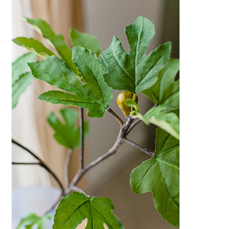 A tall Artificial Faux Fig Leaf Stem with lush green leaves, showcasing its realistic design and vibrant colors, perfect for home decor.