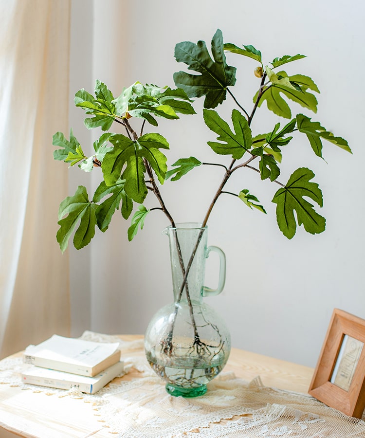 A tall Artificial Faux Fig Leaf Stem with lush green leaves, showcasing its realistic design and vibrant colors, perfect for home decor.