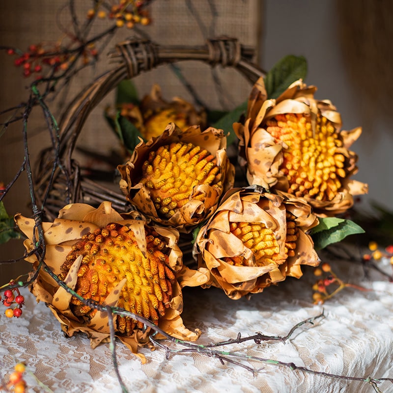 A vibrant artificial flannel sunflower stem featuring bright yellow petals and lush green leaves, perfect for home decor.