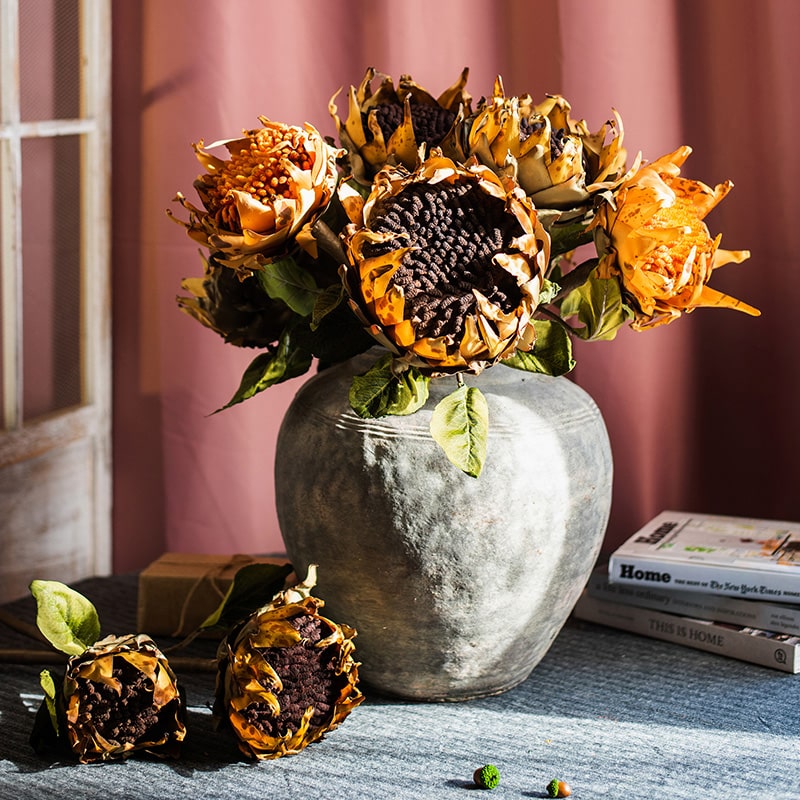 A vibrant artificial flannel sunflower stem featuring bright yellow petals and lush green leaves, perfect for home decor.