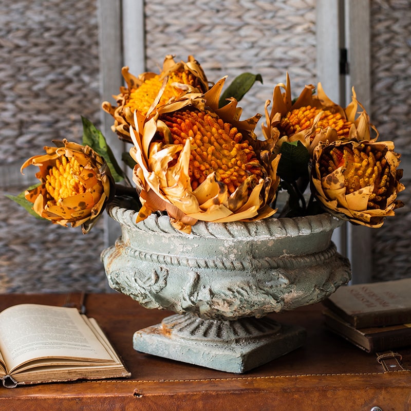 A vibrant artificial flannel sunflower stem featuring bright yellow petals and lush green leaves, perfect for home decor.