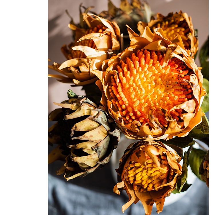 A vibrant artificial flannel sunflower stem featuring bright yellow petals and lush green leaves, perfect for home decor.