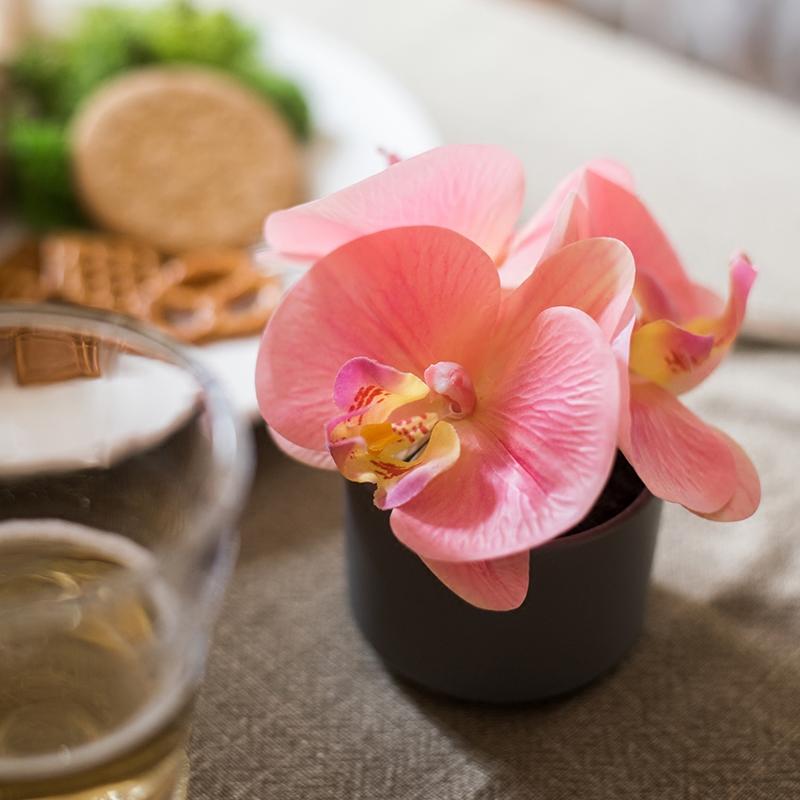 Artificial Flower Mini Real Touch Orchid in Peach Pink, showcasing vibrant petals and realistic leaves in a ceramic vase.