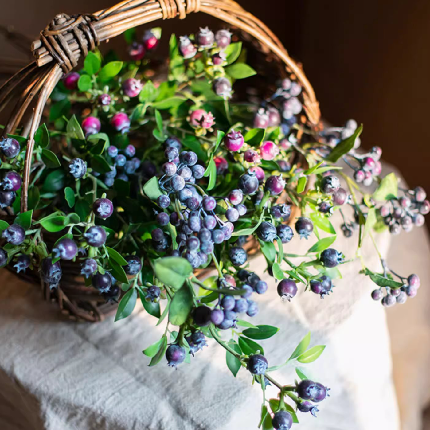 A tall 22.4-inch artificial blueberry stem featuring vibrant blue berries and lush green leaves, perfect for home decor.