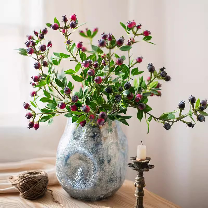 A tall 22.4-inch artificial blueberry stem featuring vibrant blue berries and lush green leaves, perfect for home decor.